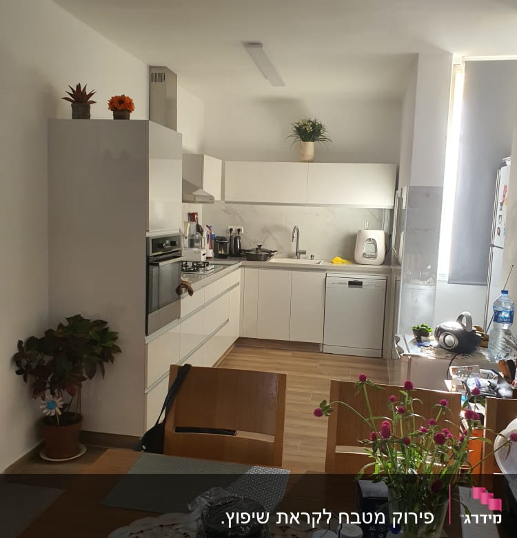 מטבח מודרני עם ארונות לבנים ומשטחי שיש